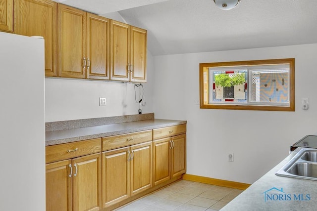 3133 126th St, Toledo, OH 43611 - kitchen featuring freestanding refrigerator, light tile patterned floors, light countertops, and brown cabinetry