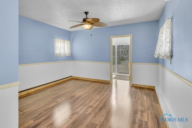 3133 126th St, Toledo, OH 43611 - spare room with ceiling fan, wood finished floors, a textured ceiling, and baseboard heating