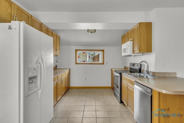 3133 126th St, Toledo, OH 43611 - kitchen with appliances with stainless steel finishes, light tile patterned floors, brown cabinetry, and light countertops