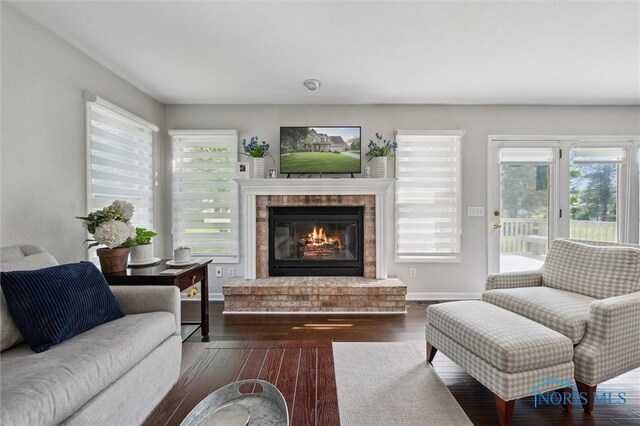 7713 Rome Ct, Holland, OH 43528 - living area featuring a brick fireplace, wood-type flooring, and healthy amount of natural light