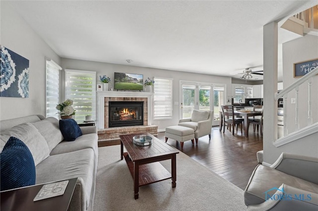 7713 Rome Ct, Holland, OH 43528 - living room featuring a brick fireplace, wood finished floors, and a ceiling fan