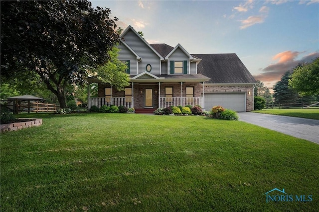 7713 Rome Ct, Holland, OH 43528 - view of front of house featuring covered porch, a garage, driveway, brick siding, and a gazebo