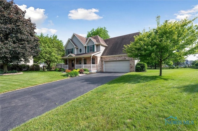7713 Rome Ct, Holland, OH 43528 - traditional home with driveway, a garage, covered porch, brick siding, and a front yard