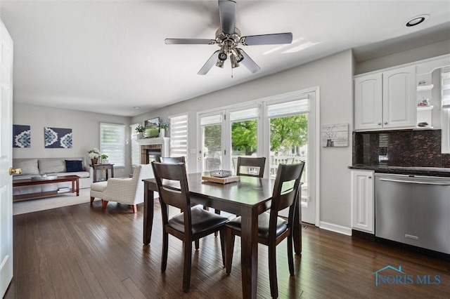 7713 Rome Ct, Holland, OH 43528 - dining space featuring healthy amount of natural light, dark wood-style flooring, a ceiling fan, and a glass covered fireplace