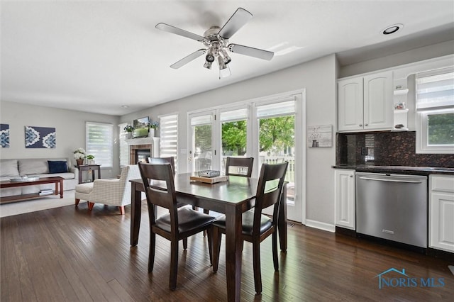 7713 Rome Ct, Holland, OH 43528 - dining area with dark wood-type flooring, ceiling fan, and a glass covered fireplace