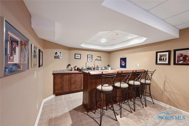 7713 Rome Ct, Holland, OH 43528 - indoor wet bar featuring a tray ceiling, light tile patterned floors, and recessed lighting