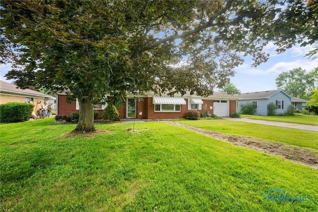 3171 Astor Ave, Toledo, OH 43614 - view of front facade with driveway, a garage, a front yard, and brick siding