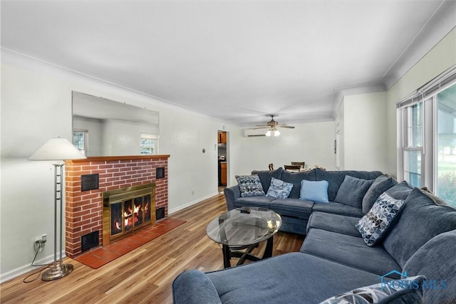 3171 Astor Ave, Toledo, OH 43614 - living room with wood finished floors, a brick fireplace, a ceiling fan, crown molding, and a wall unit AC