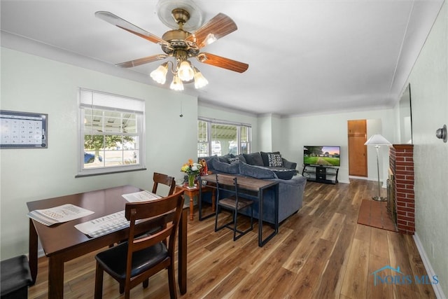 3171 Astor Ave, Toledo, OH 43614 - dining room with wood finished floors, a fireplace, and ceiling fan