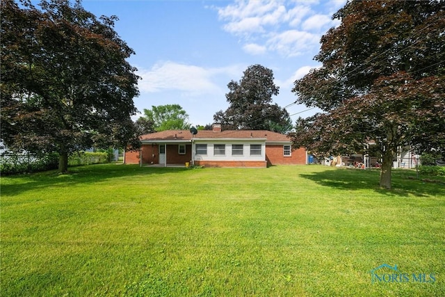 3171 Astor Ave, Toledo, OH 43614 - rear view of property with a yard, brick siding, and a chimney