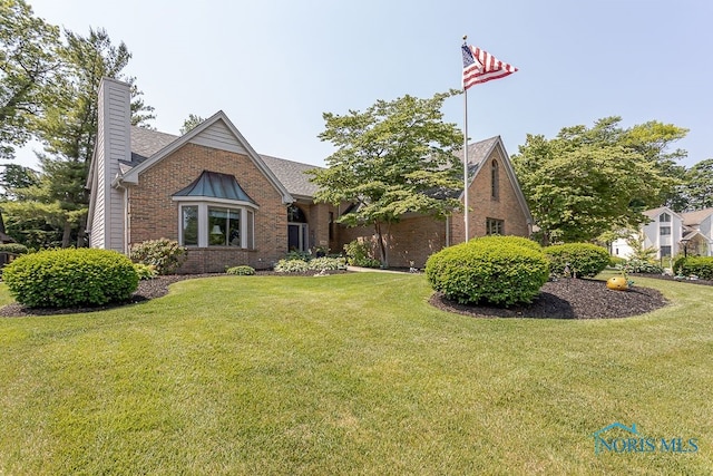 7325 Winsford Ln, Sylvania, OH 43560 - tudor house with brick siding, a front lawn, and a chimney