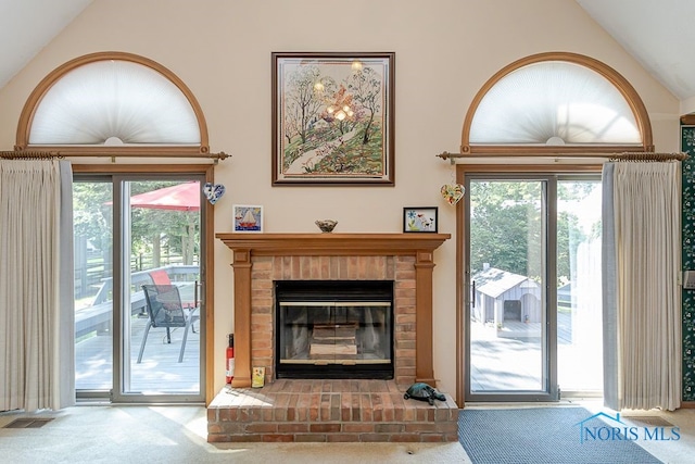 7325 Winsford Ln, Sylvania, OH 43560 - carpeted living room with vaulted ceiling, plenty of natural light, and a brick fireplace