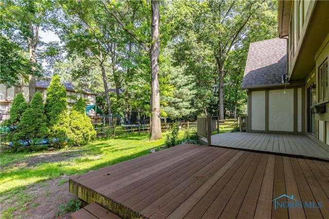 2325 Saint Roberts Ln, Toledo, OH 43617 - deck featuring a trampoline, a yard, and view of wooded area