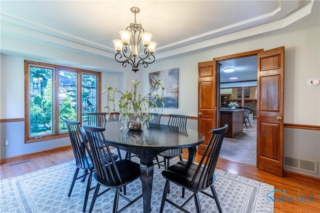 2325 Saint Roberts Ln, Toledo, OH 43617 - dining area featuring a chandelier, light wood-style floors, and a tray ceiling
