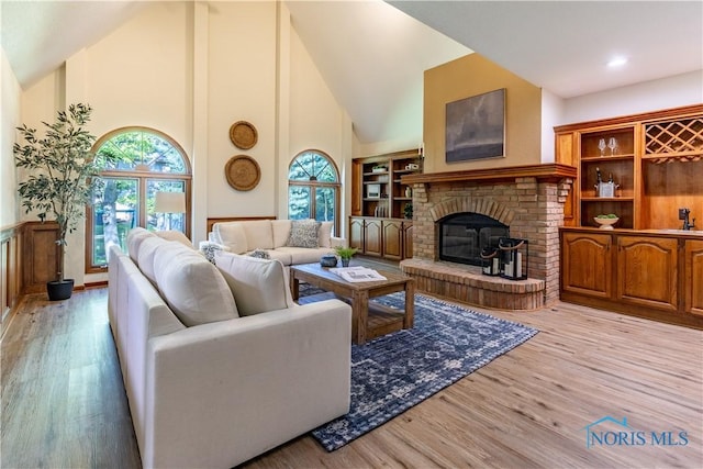 2325 Saint Roberts Ln, Toledo, OH 43617 - living area featuring light wood finished floors, high vaulted ceiling, and a fireplace