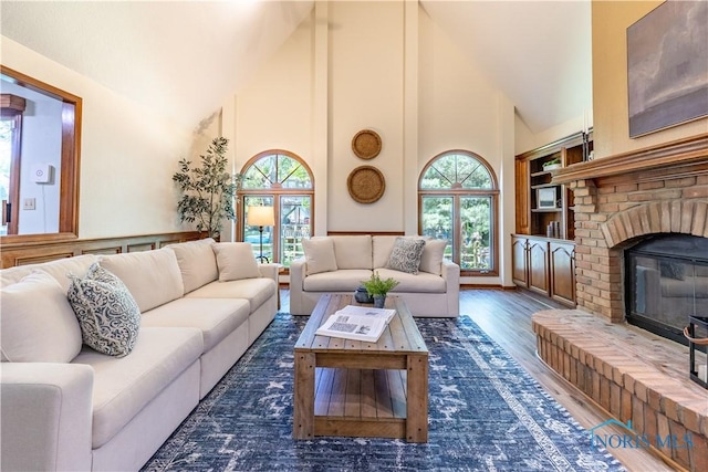 2325 Saint Roberts Ln, Toledo, OH 43617 - living room with high vaulted ceiling, a brick fireplace, plenty of natural light, and wood finished floors