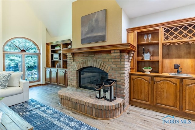 2325 Saint Roberts Ln, Toledo, OH 43617 - living room with light wood finished floors, a fireplace, and high vaulted ceiling