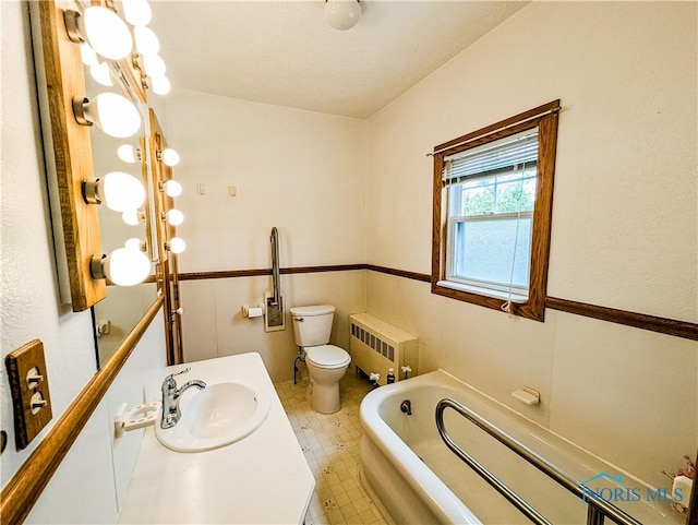 120 Elm St, Fostoria, OH 44830 - bathroom featuring radiator heating unit, a bath, vanity, and tile patterned floors