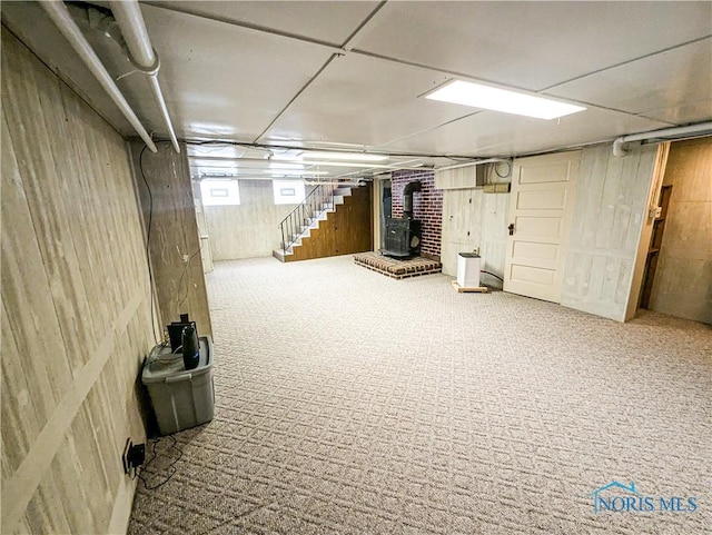 120 Elm St, Fostoria, OH 44830 - basement with a wood stove, wood walls, stairway, carpet flooring, and heating unit