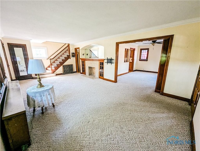 120 Elm St, Fostoria, OH 44830 - unfurnished living room with a fireplace, ornamental molding, carpet, stairway, and arched walkways