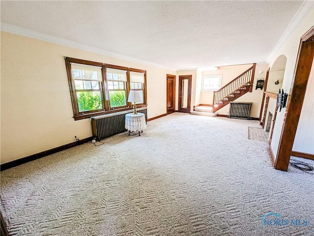 120 Elm St, Fostoria, OH 44830 - spare room with radiator heating unit, carpet floors, ornamental molding, stairway, and a textured ceiling