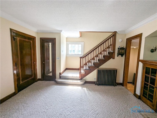 120 Elm St, Fostoria, OH 44830 - carpeted foyer entrance with radiator, ornamental molding, stairway, and a textured ceiling