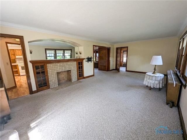 120 Elm St, Fostoria, OH 44830 - unfurnished living room featuring carpet floors, ornamental molding, a tile fireplace, and arched walkways