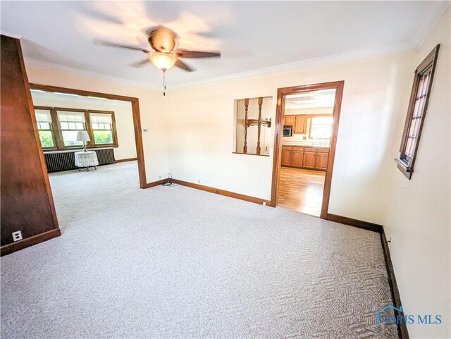 120 Elm St, Fostoria, OH 44830 - unfurnished room featuring carpet flooring, ceiling fan, crown molding, and radiator heating unit