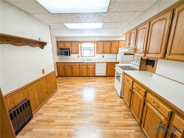 120 Elm St, Fostoria, OH 44830 - kitchen with white appliances, light wood finished floors, brown cabinets, light countertops, and a wainscoted wall