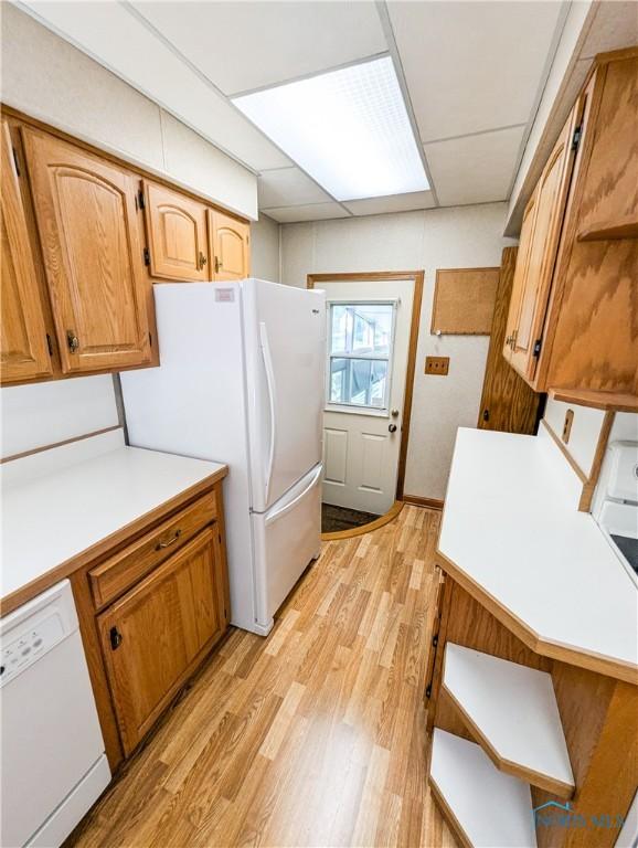 120 Elm St, Fostoria, OH 44830 - kitchen featuring white appliances, light wood finished floors, light countertops, and brown cabinetry