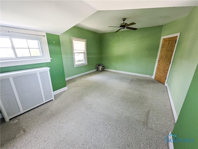 120 Elm St, Fostoria, OH 44830 - carpeted spare room featuring radiator heating unit, a ceiling fan, and vaulted ceiling