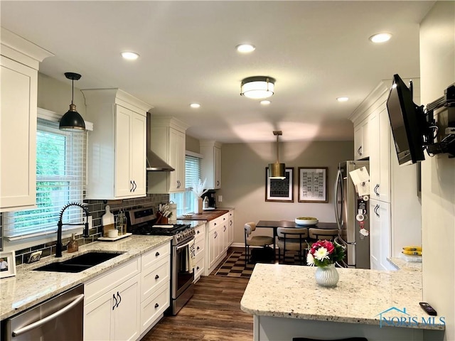 3822 Sylvan Wood Dr, Sylvania, OH 43560 - kitchen with stainless steel appliances, white cabinets, plenty of natural light, wall chimney range hood, and recessed lighting