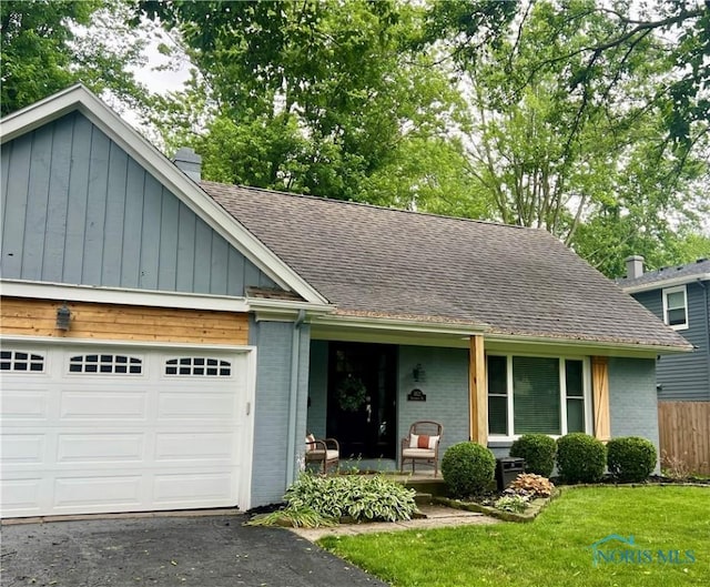 3822 Sylvan Wood Dr, Sylvania, OH 43560 - view of front facade featuring brick siding, a shingled roof, a garage, and a chimney