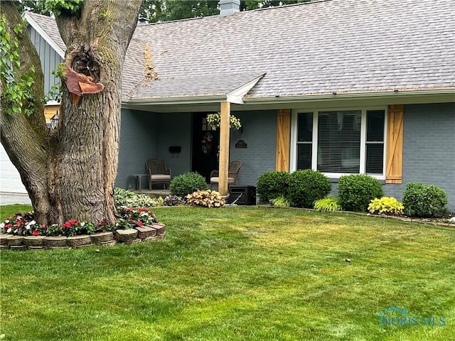 3822 Sylvan Wood Dr, Sylvania, OH 43560 - property entrance featuring brick siding, a chimney, a yard, and a shingled roof