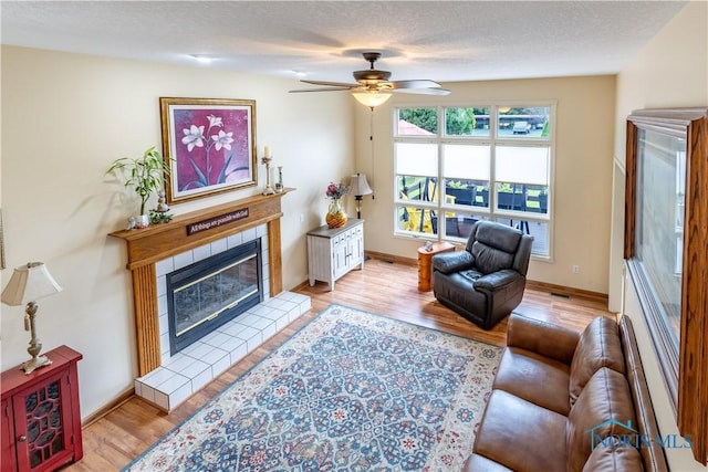 6666 Brick Yard Ct, Maumee, OH 43537 - living area featuring a tile fireplace, light wood-style floors, and a ceiling fan