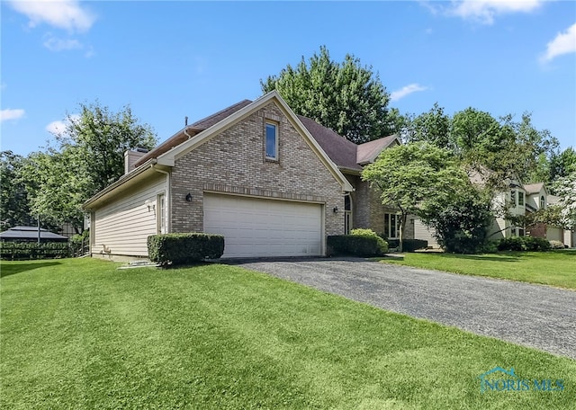 7257 Wembley Ter, Toledo, OH 43617 - view of front of property featuring brick siding, asphalt driveway, an attached garage, a front yard, and a chimney