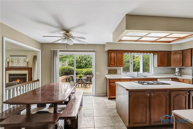 7257 Wembley Ter, Toledo, OH 43617 - kitchen with light countertops, ceiling fan, plenty of natural light, and a warm lit fireplace