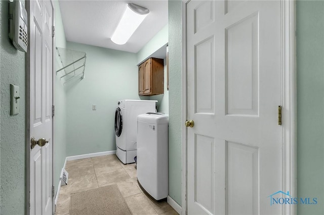 7257 Wembley Ter, Toledo, OH 43617 - laundry room with cabinet space, washing machine and dryer, and light tile patterned floors