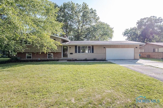 2338 Greenlawn Dr, Toledo, OH 43614 - tri-level home with a garage, concrete driveway, a front lawn, and brick siding