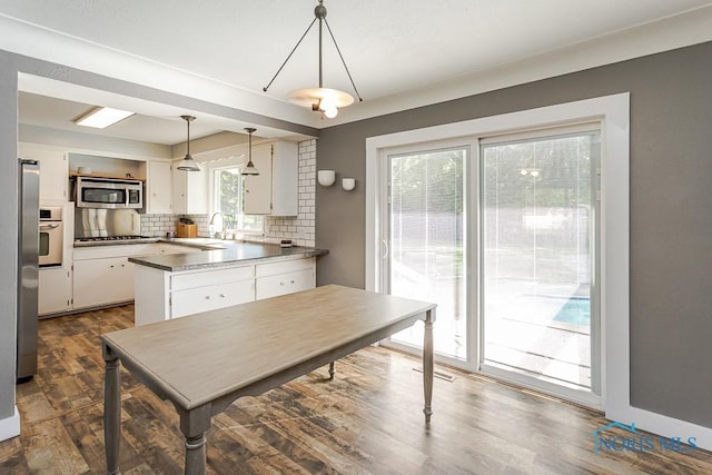 2338 Greenlawn Dr, Toledo, OH 43614 - kitchen featuring appliances with stainless steel finishes, white cabinetry, decorative backsplash, a peninsula, and decorative light fixtures
