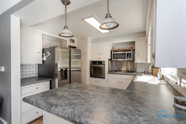 2338 Greenlawn Dr, Toledo, OH 43614 - kitchen featuring appliances with stainless steel finishes, dark countertops, decorative backsplash, a peninsula, and white cabinets