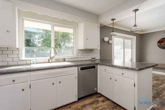 2338 Greenlawn Dr, Toledo, OH 43614 - kitchen with stainless steel dishwasher, dark countertops, a peninsula, and white cabinetry