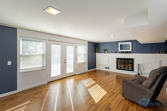 2338 Greenlawn Dr, Toledo, OH 43614 - living area with healthy amount of natural light, french doors, wood finished floors, and a brick fireplace