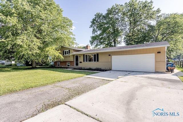 2338 Greenlawn Dr, Toledo, OH 43614 - tri-level home with an attached garage, concrete driveway, a front yard, and a chimney