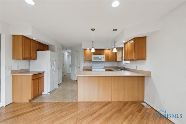 26332 Whitewater Dr, Perrysburg, OH 43551 - kitchen featuring white appliances, a peninsula, light countertops, recessed lighting, and light wood finished floors
