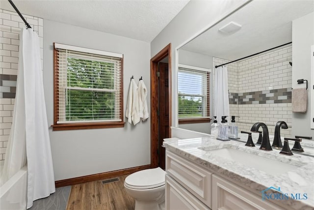 824 Edgehill Rd, Findlay, OH 45840 - bathroom with vanity, healthy amount of natural light, wood finished floors, shower / tub combo, and a textured ceiling