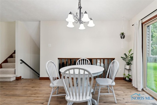 824 Edgehill Rd, Findlay, OH 45840 - dining space featuring light wood-type flooring, a chandelier, and stairs