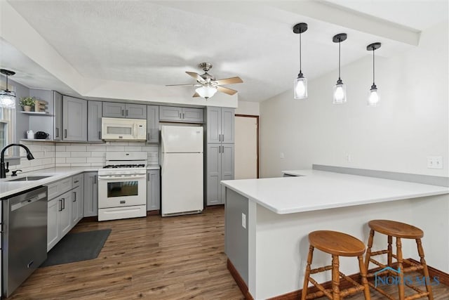 824 Edgehill Rd, Findlay, OH 45840 - kitchen featuring white appliances, a peninsula, dark wood finished floors, gray cabinets, and tasteful backsplash
