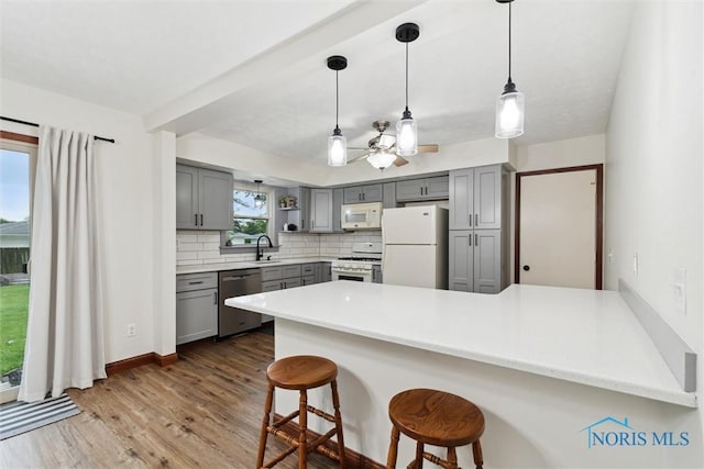 824 Edgehill Rd, Findlay, OH 45840 - kitchen with white appliances, gray cabinetry, a peninsula, backsplash, and a ceiling fan