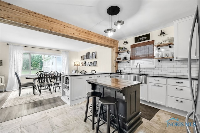 550 W 2nd St, Perrysburg, OH 43551 - kitchen featuring open shelves, a peninsula, decorative backsplash, a breakfast bar, and white cabinetry